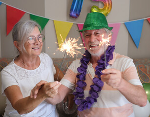 Two cheerful Caucasian seniors celebrating 75th birthday with sparkles, a moment of joy to share together