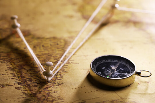 Old World Map with Compass and String Marking Travel Route Across Continents