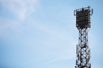 Tall Communication Tower Against Clear Blue Sky with Multiple Antennas and Structural Framework