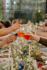 Cheers! Group of people cheering with champagne flutes with wedding interior in the background