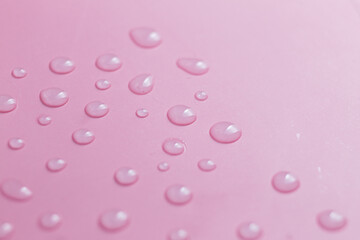 Pink background. Water drops on pink background close up