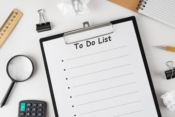 to do list on clipboard with office supplies, isolated on white background