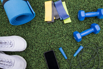 fitness equipment on green grass background. Sports equipment, sports accessories on grass. Concept of sports, fitness.