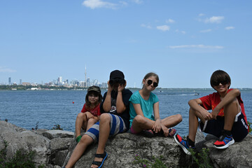 Obraz premium children on the background of the city of Toronto and the lake,