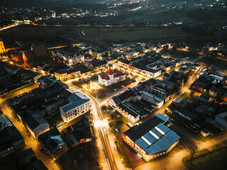 Miasto nocą z powietrza, oświetlone ulice i budynki    © Kacper