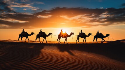 Camel caravan walking through desert at sunset	