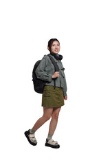 Fototapeta premium Portrait of Asian female student wearing backpack, headphones, fashionable clothes, posing dynamically on white background