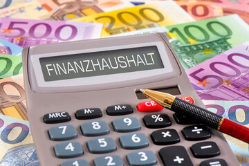 Über vielen Euroscheinen liegt ein Taschenrechner mit der Aufschrift Finanzhaushalt im Display