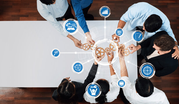 A diverse team engages in collaborative brainstorming, leveraging gear symbols and data icons to symbolize innovative strategies and effective teamwork in a modern office environment. Amity