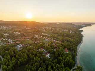 Breathtaking aerial view Kassandra peninsula Greece, sunset summer Mediterranean town crystal-clear sea red-roofed village, green pine forest beach resort, coastal scenery, perfect holiday