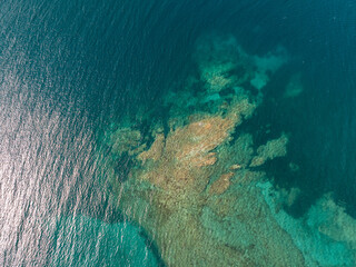 Greece Rocky coast of peninsula. Pattern of sea surface and rocky shore. Thracian Sea. Aerial view of slide turn from drone on view of calm turquoise sea water and rocks from molten lava. Travel