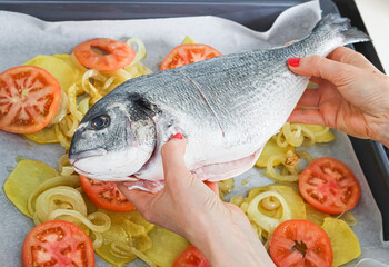 Baked dorada (sea bream) with onion and tomato