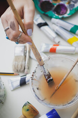 Woman Painting on Canvas with Brushes and Colors