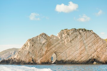 Greece offers stunning rock formations rising majestically from the tranquil sea under a clear blue sky. Visitors can explore the breathtaking coastline while enjoying summer sunshine