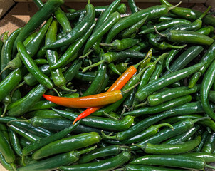 Colorful chili peppers in a wooden crate at local market
