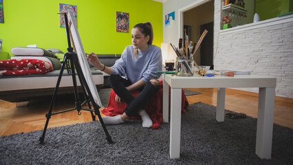 Woman Painting on Canvas with Brushes and colors