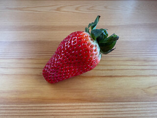 Fresh strawberries in a wooden crate on a wooden table
