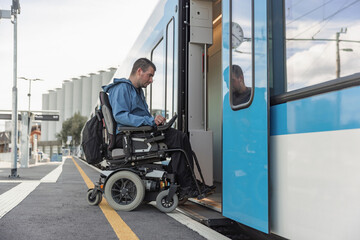 Man with disability on electric wheelchair entering a train. Accessible travel and inclusive...