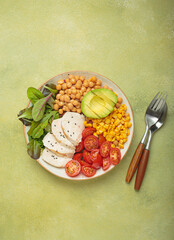 Healthy bowl with grilled chicken breast, chickpeas, avocado, corn and tomatoes, a balanced and nutritious meal promoting well being and a healthy lifestyle