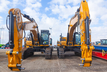 New yellow crawler excavators are parked on the site.