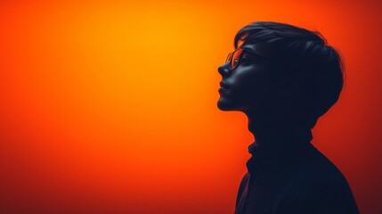 A silhouette of a man wearing glasses against an orange background