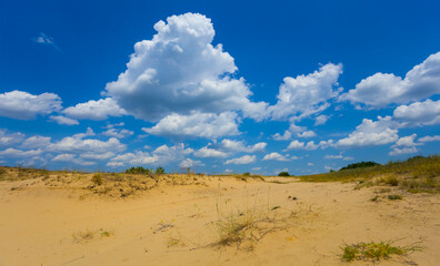 wide sandy desert under a blue cloudy sky