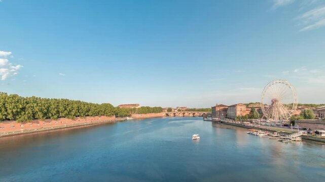 Panorama showing waterfront of Garonne River and Pont Neuf timelapse with Museum of the History of Medicine and ferris wheel in downtown Toulouse, France. Aerial view from Saint Pierre Bridge