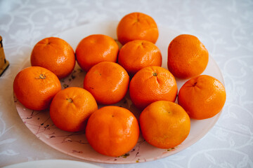 A beautifully crafted wooden table holds a large plate of fresh, juicy oranges, ripe for a nutritious snack or flavorful ingredient, offering a burst of citrusy goodness