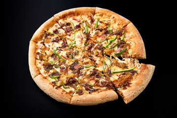 pizza with meat on a black background