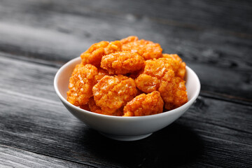 Spicy chilli rice crackers in white bowl. Party food snacks