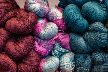 Colorful hand-dyed skeins of wool yarn in jewel tones