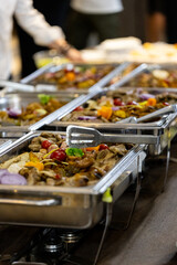 Catering display with various dishes during a vibrant social event in an indoor space