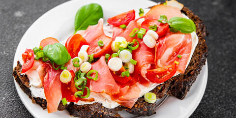 Bruschetta ham, tomato, greens dish fresh delicious gourmet food background on the table rustic food top view copy space