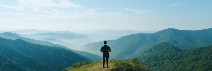 Young male admiring mountain view in serene landscape
