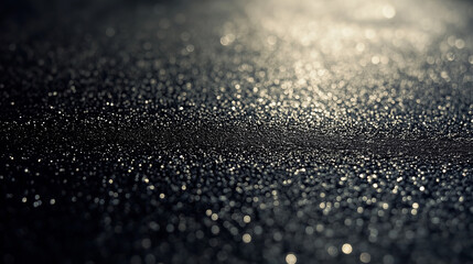 A textured black sand background with tiny grains
