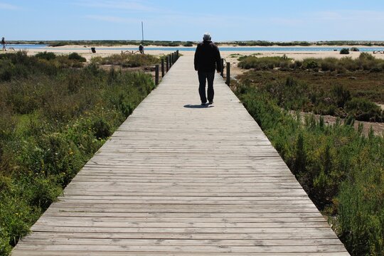 Old man walking to the beach 