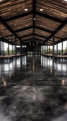Spacious hall with polished floors, exposed beams, and light streaming in. Tables are lined up