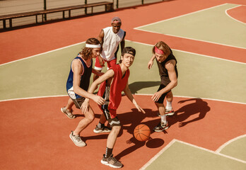 Fototapeta premium Team of professional basketball players fighting for ball on outdoor arena