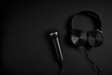 black microphone and headphones on a black background