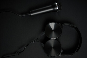 black microphone and headphones on a black background