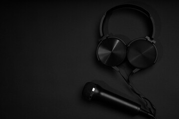 black microphone and headphones on a black background