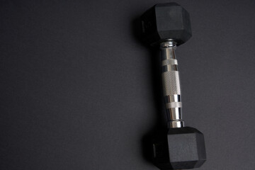 Black metal dumbbells on a black backdround