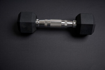Black metal dumbbells on a black backdround