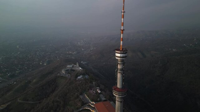Kok Tobe TV Tower. Mountainous terrain. The view from the drone. Spring time. Clouds and smog.