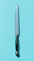 A stainless steel knife resting on a blue background surface