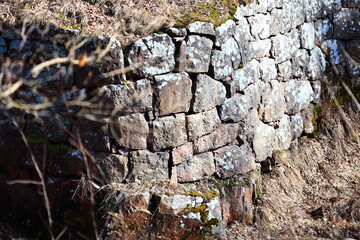 Old stone wall overgrown with moss and lichen.