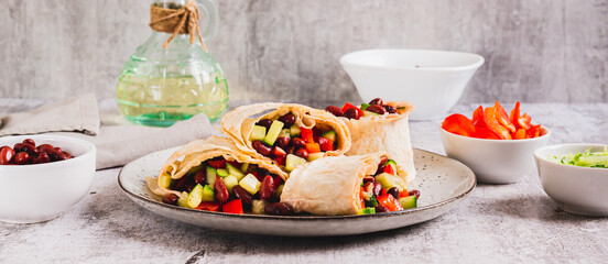Salad of beans, cucumber and pepper in lavash rolls on a plate on the table web banner