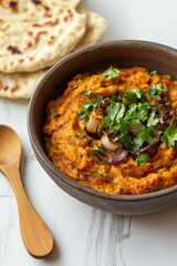 Fototapeta premium Indian Curry - Baingan Ka Bharta with Roasted Garlic and Tomatoes, Topped with Caramelized Onions and Coriander