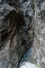 Nestled within the rugged mountains of Northern Ossetia, a swift river navigates through narrow rocky canyons, showcasing nature's raw beauty and geological wonders in a serene environment