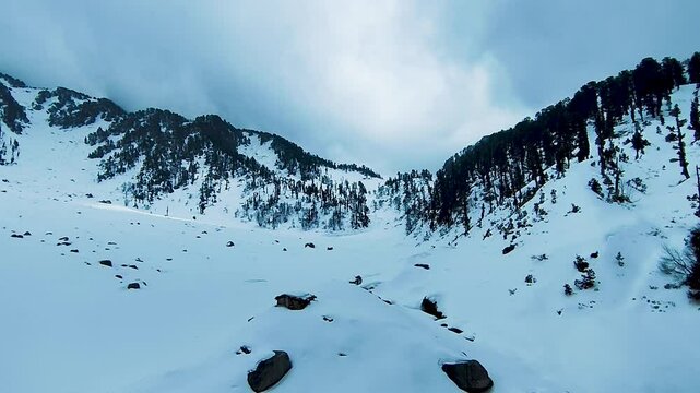 Frozen Kareri Lake and Mountains  covered with white Snow and water made a sign of omm in frozen lake. Dharamshala Himachal Pradesh.